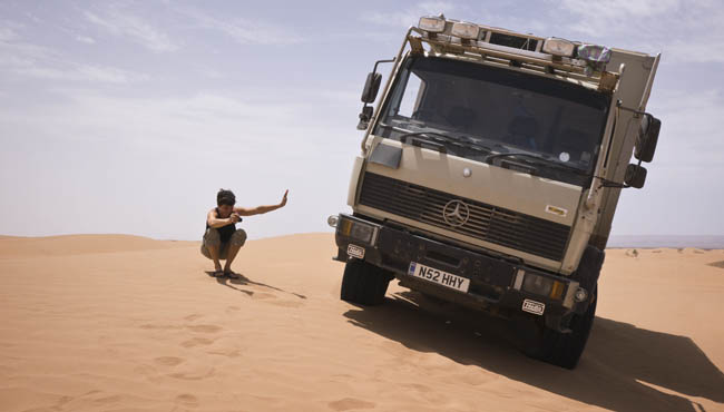 Driving truck in sand dunes sahara